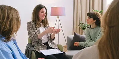 An NDIS guide meeting with a family in a living room