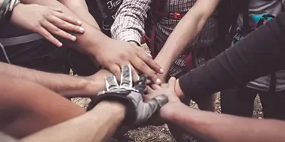 A group of people joining hands in a circle